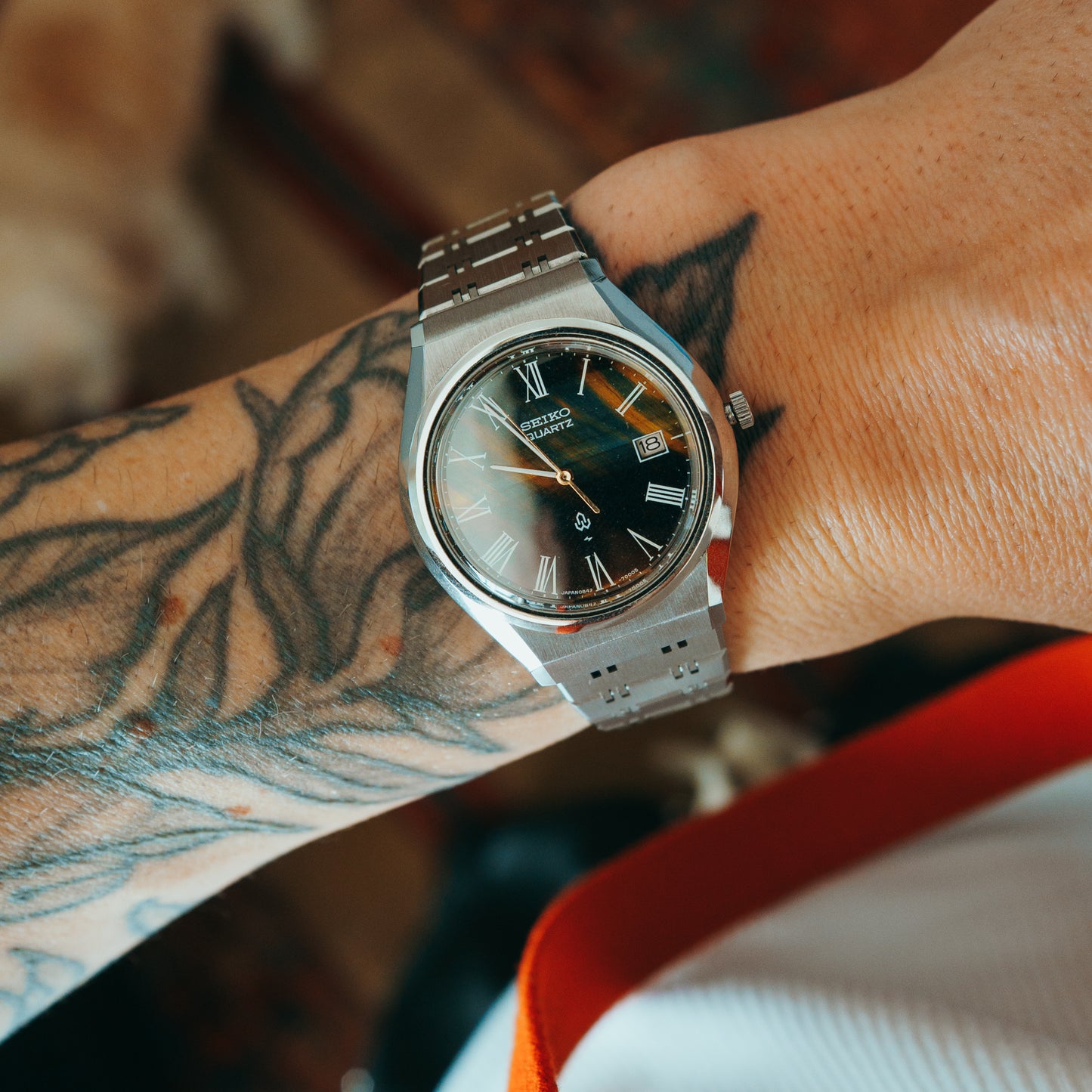 Seiko Quartz tigers eye gradient dial with Roman numerals front view on wrist