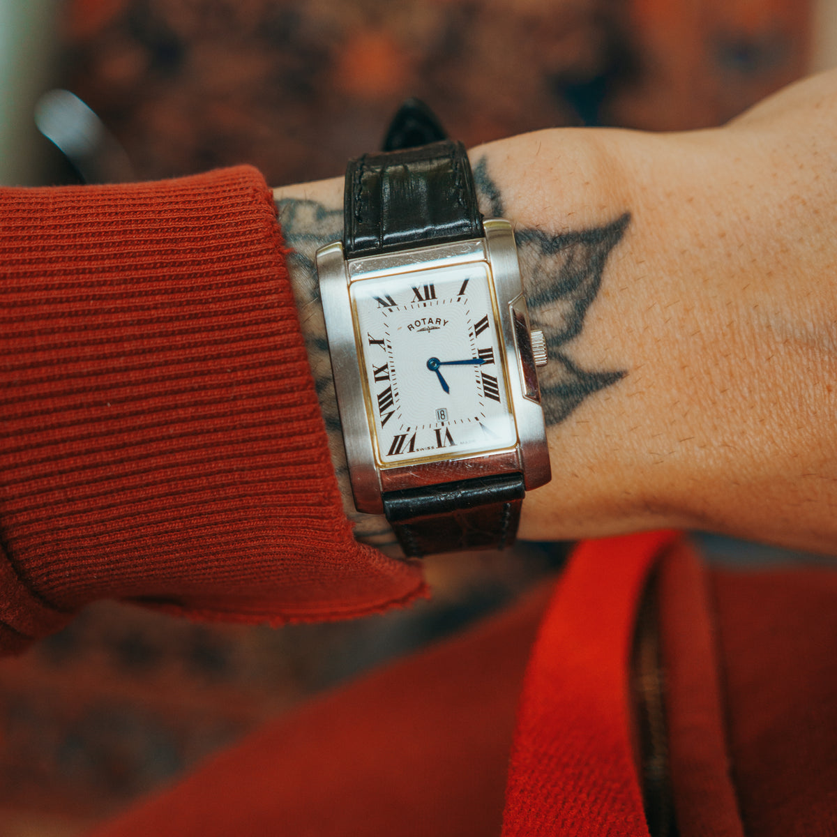 Rotary rectangular watch crown guard and screws on wrist