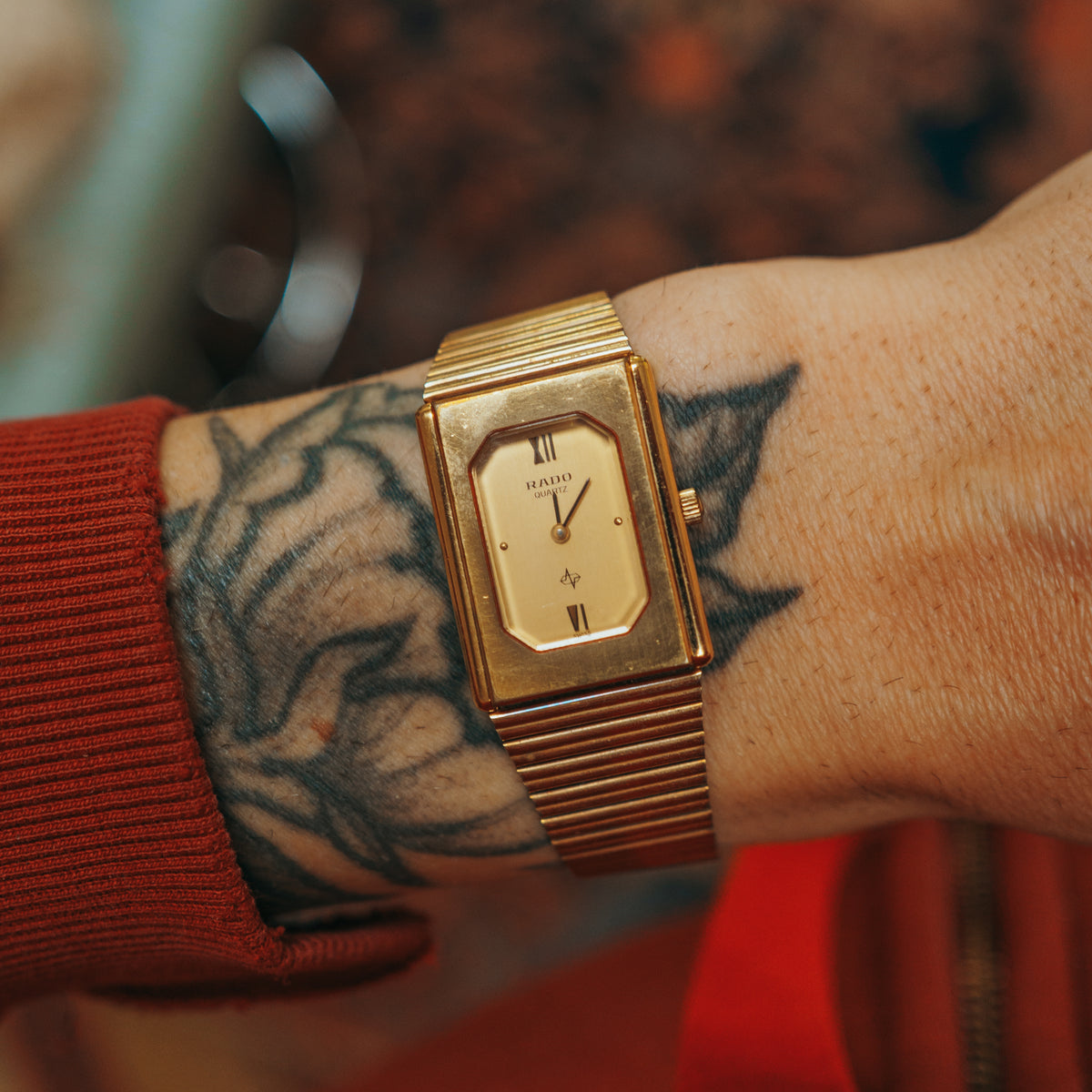 Rado Quartz gold-tone rectangular watch face on wrist
